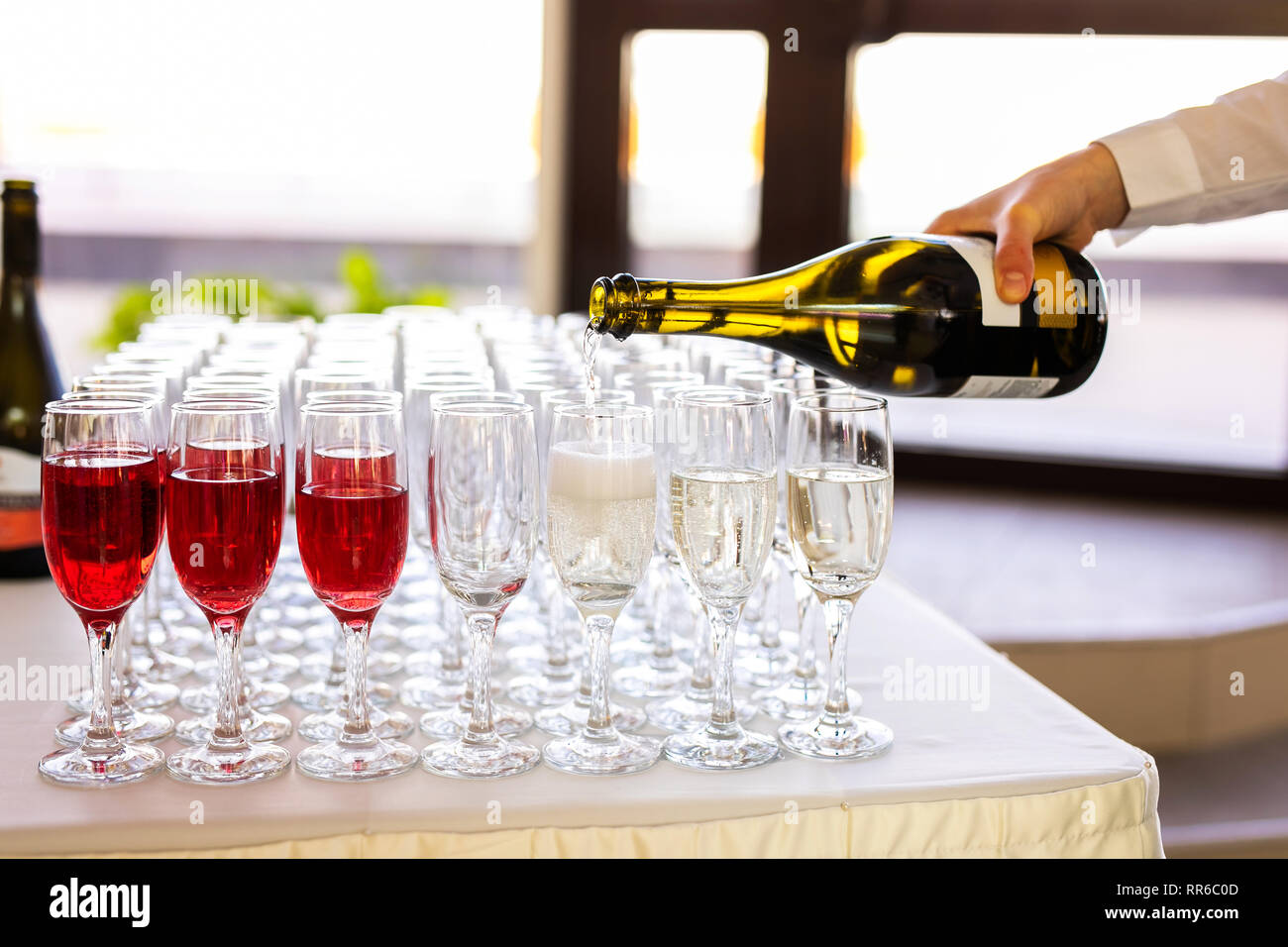 Il cameriere versa dello Champagne in bicchieri sulla strada catering per matrimoni Foto stock Alamy