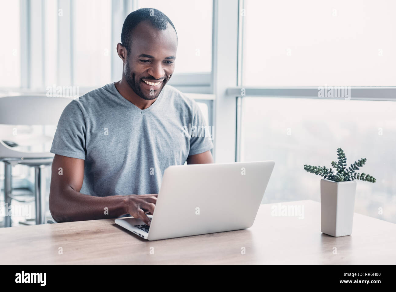 Professional economista maschio cerca le informazioni necessarie sul computer portatile, felice di ricevere ad alto profitto netto, spende importante operazione bancaria. Af Foto Stock