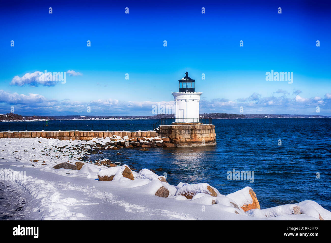 Il Portland Maine frangionde faro, chiamato anche il bug di luce, su un piccolo molo coperto di neve su un soleggiato blue sky giorno d'inverno. Foto Stock