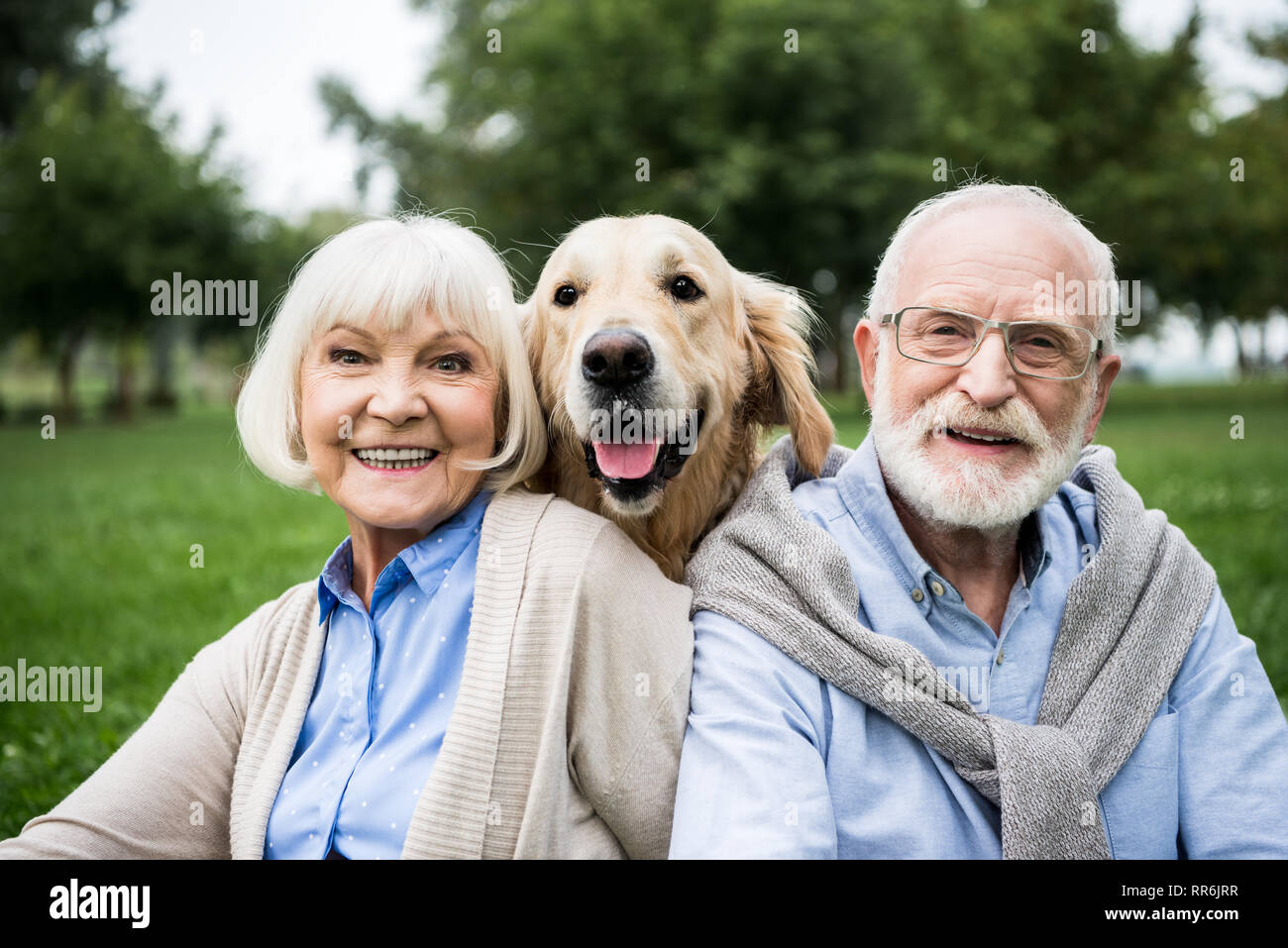 Felice coppia senior con adorabili golden retriever cane in posizione di parcheggio Foto Stock