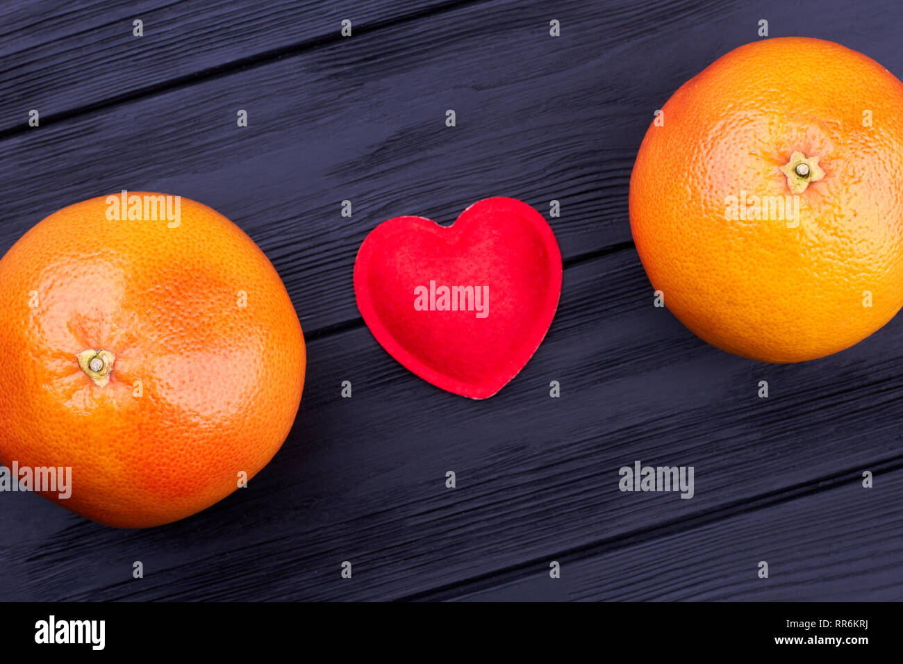 Due interi pompelmi e cuore rosso. Foto Stock