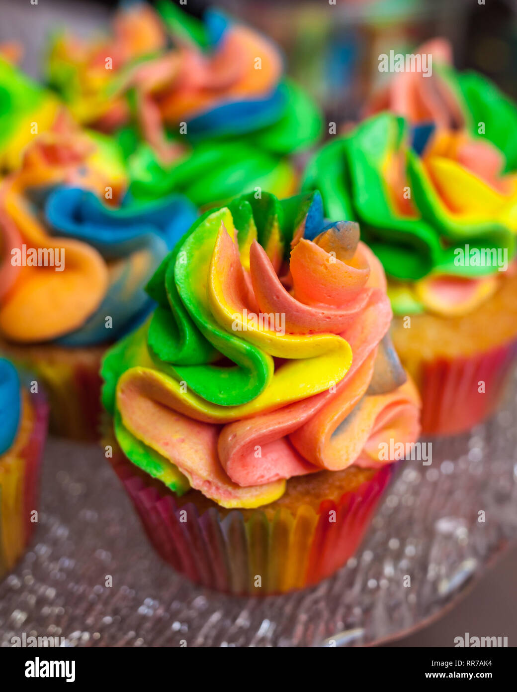 Colorato tortine con crema di arcobaleno per carnevale Foto Stock