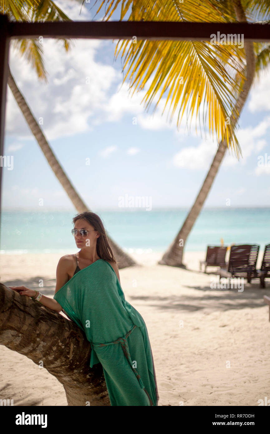Donna in sotto una palma godendo la spiaggia Caraibica Foto Stock