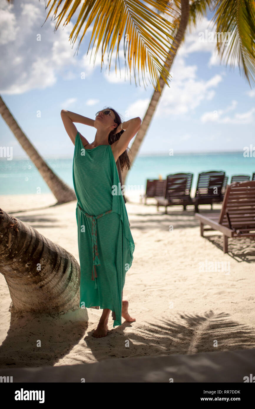 Donna in sotto una palma godendo la spiaggia Caraibica Foto Stock