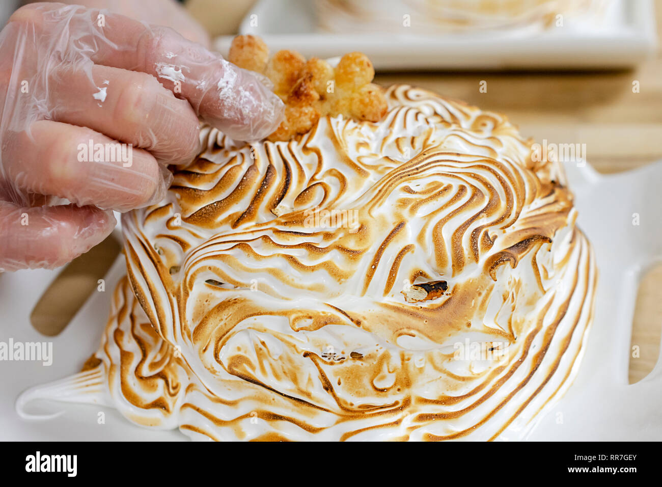 Studente di cucina luoghi piccoli i cookie su una meringa tostato dessert. Foto Stock