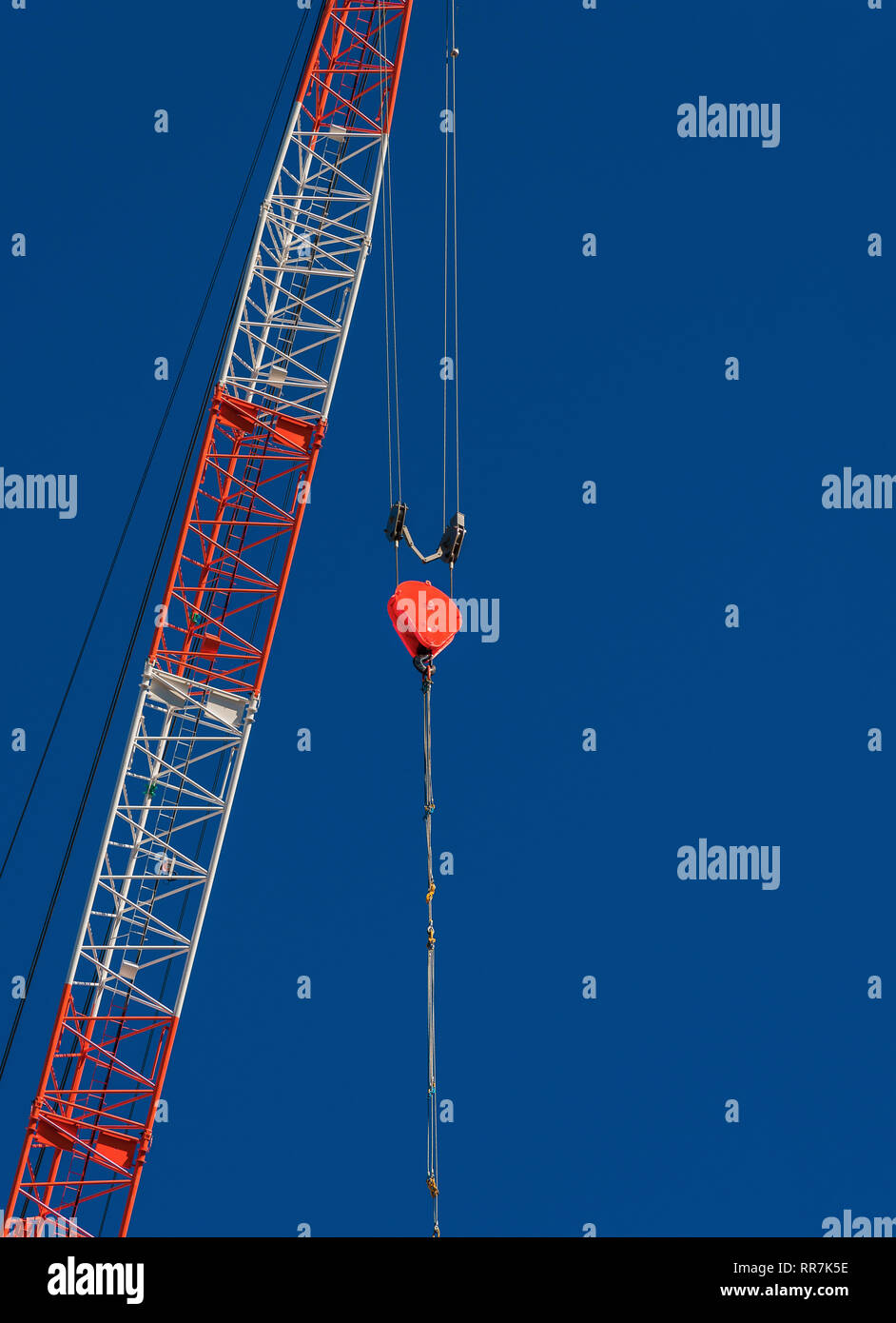 Red Hook sospesa da una gru da cantiere, contro un cielo blu Foto Stock