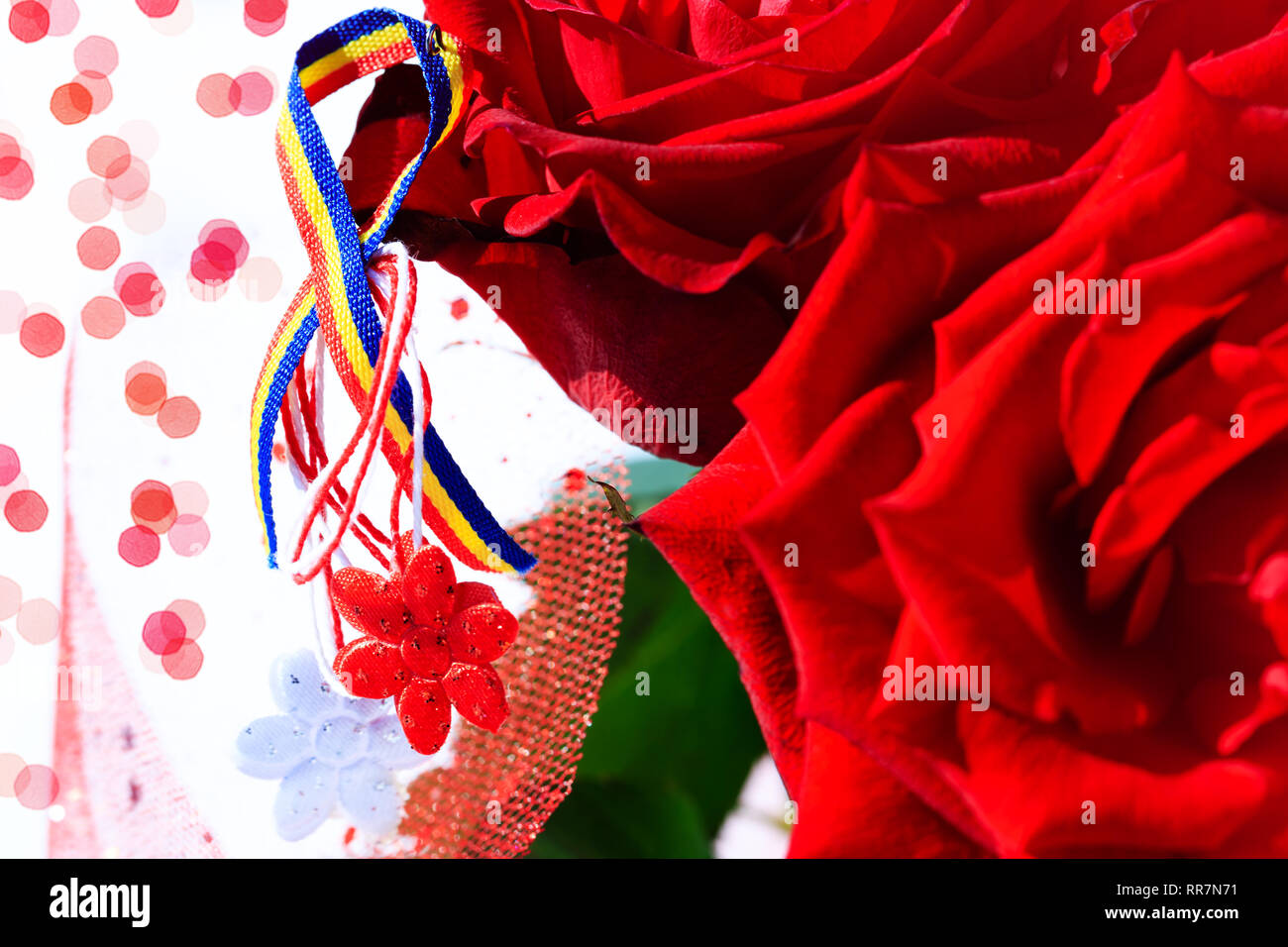 Martisor con rumeno elementi tricolore, rose rosse e decorativo sullo sfondo di vacanza. Moldavo rumeno e la molla e il simbolo d'amore. Martisor è un re Foto Stock