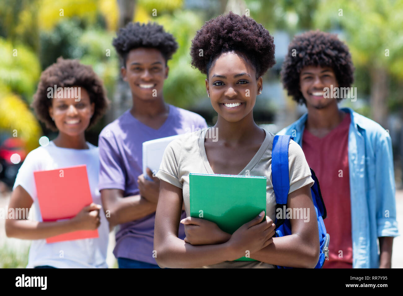 African studentessa con gruppo di African American studenti all'aperto in estate Foto Stock