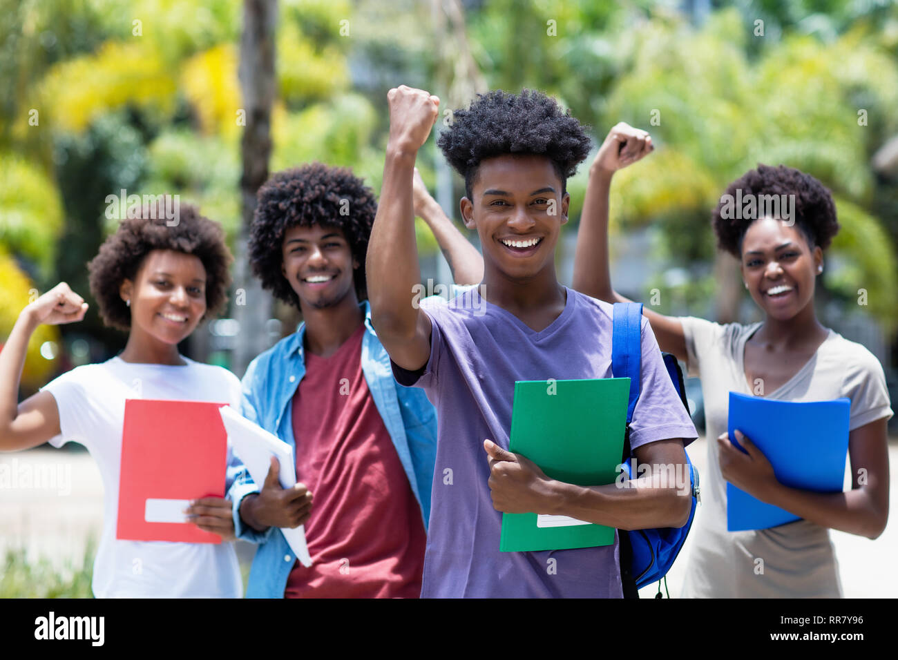 Il tifo africano studente maschio con gruppo di African American studenti all'aperto in estate Foto Stock