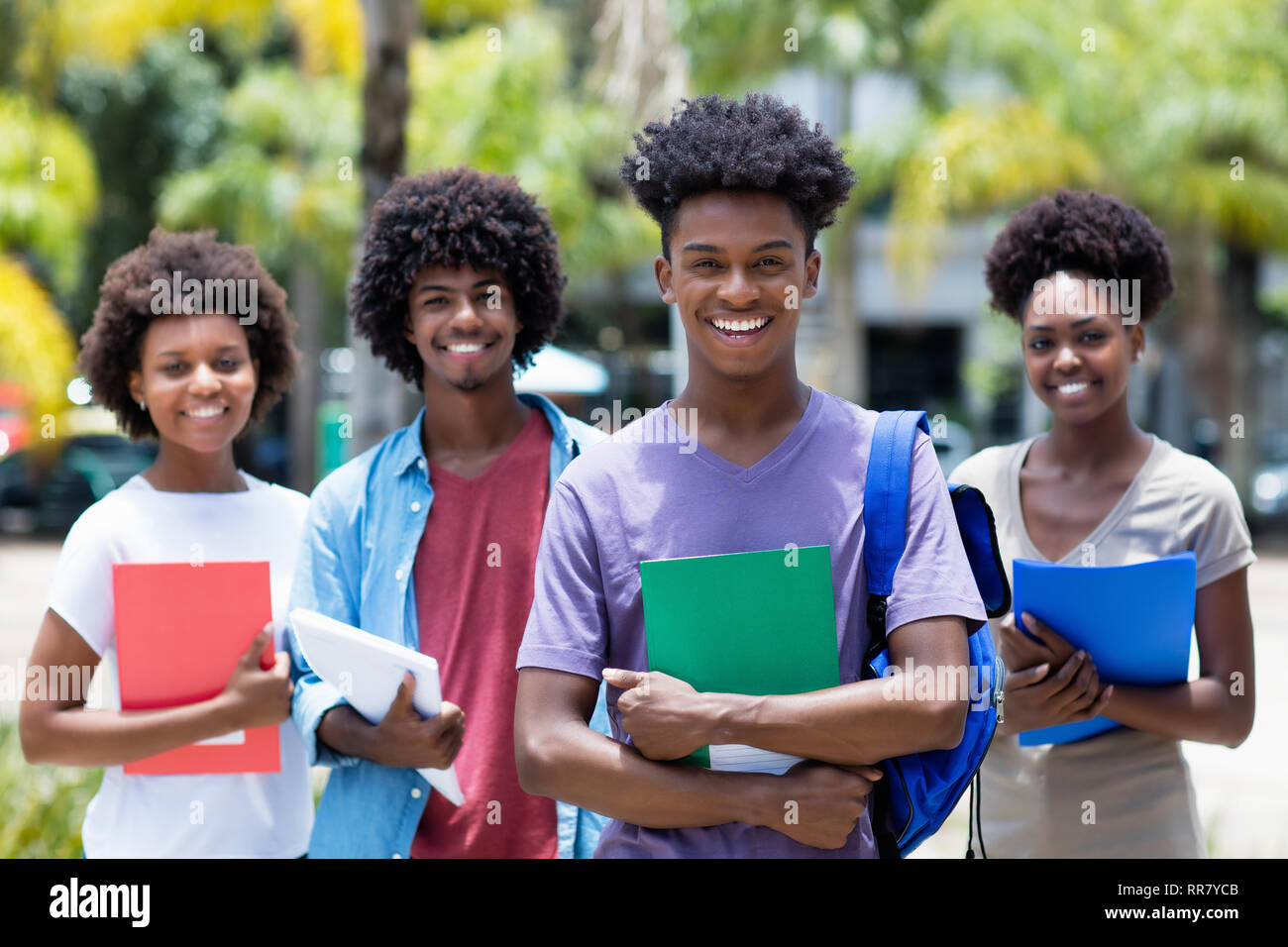 Africa studente maschio con gruppo di African American studenti all'aperto in estate Foto Stock