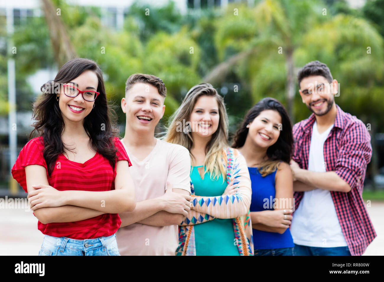 Ragazza francese con il maschio e la femmina adulti giovani in linea outdoor in città Foto Stock
