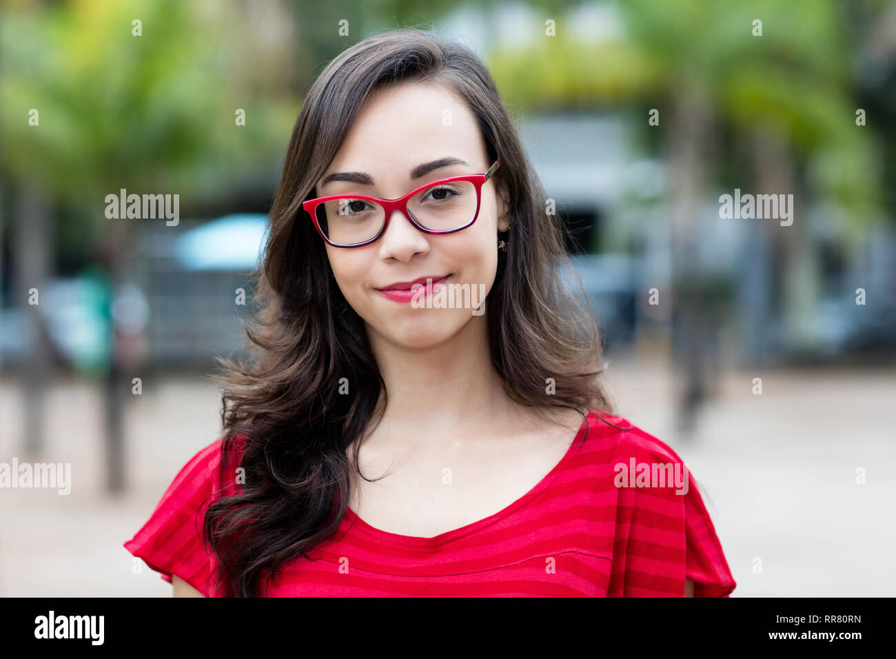 Sorridente giovane donna francese con i bicchieri all'aperto in estate in città Foto Stock