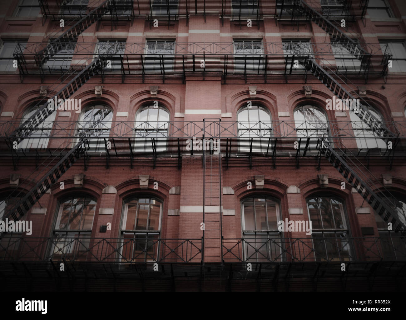 Un edificio di appartamenti a New York con fuoco sfugge, arcuate keystone windows, ornamentali ringhiera e simmetria. Foto Stock