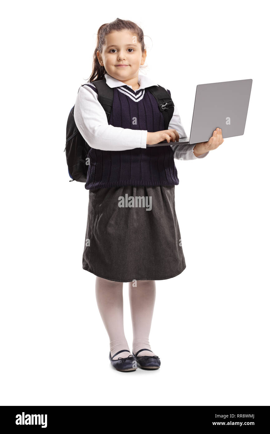 A piena lunghezza Ritratto di un little schoolgirl in uniforme in possesso di un computer portatile e in posa isolati su sfondo bianco Foto Stock