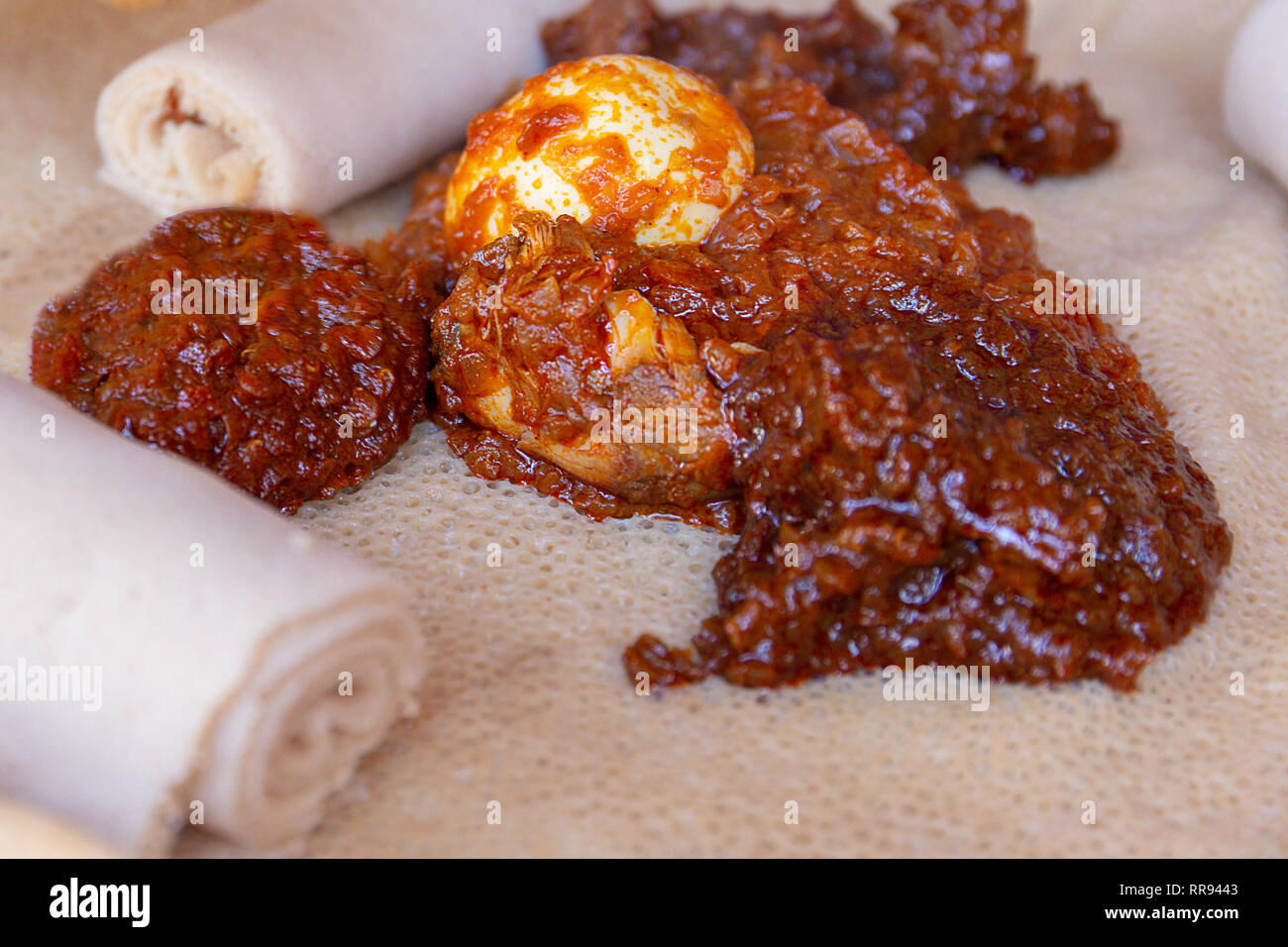 Ristoranti africani. Pollo e uovo Doro Wat con Injera - una pasta madre flatbread realizzato da teff farina. È il cibo nazionale dell'Etiopia, Eritrea, Somalia Foto Stock