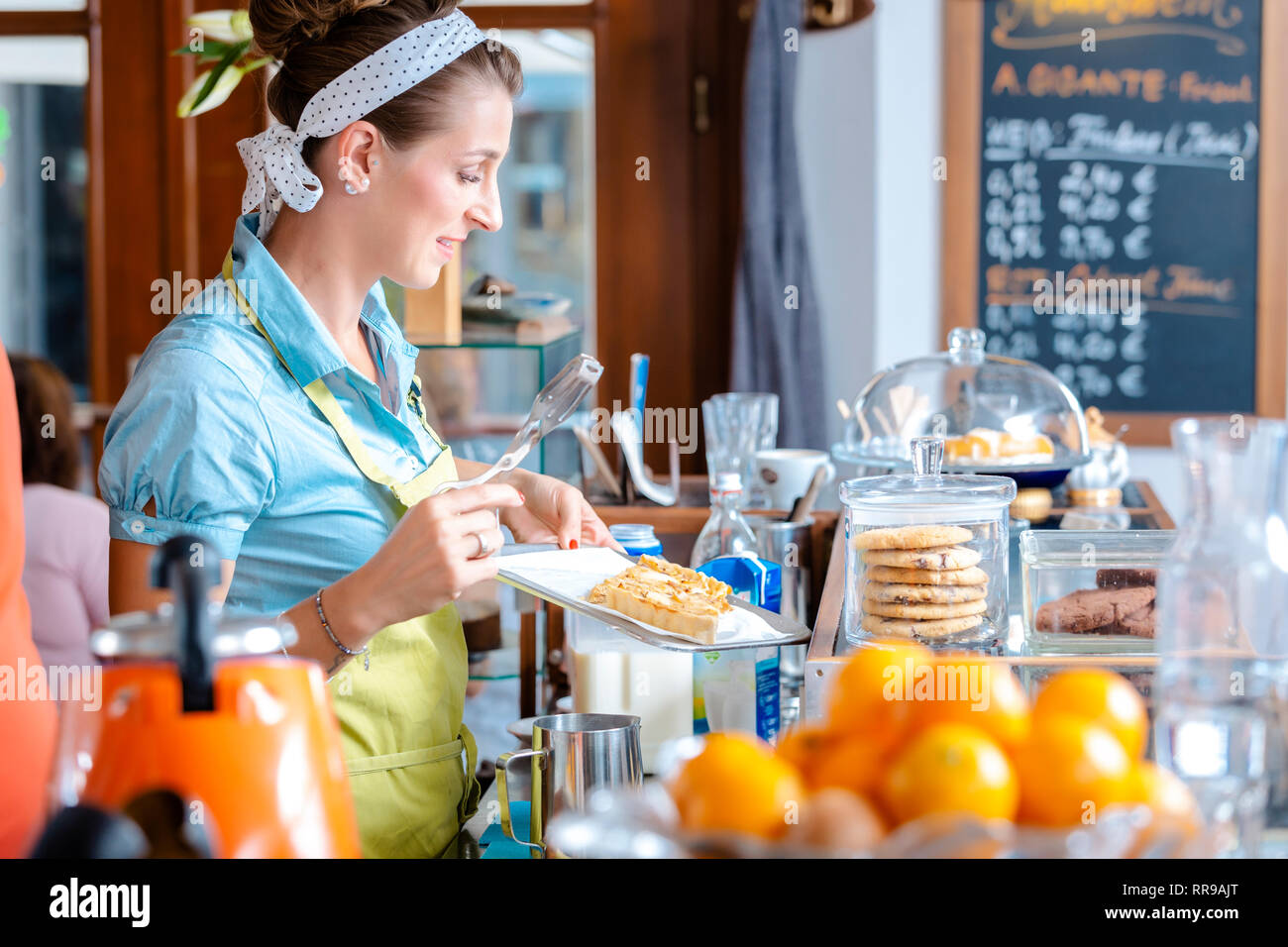 Donna che mantiene la pasticceria nel vassoio Foto Stock