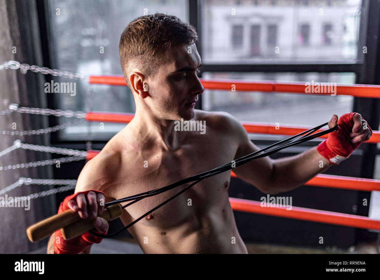 Atleta muscolare boxer uomo tenendo la corda in l'anello Foto Stock