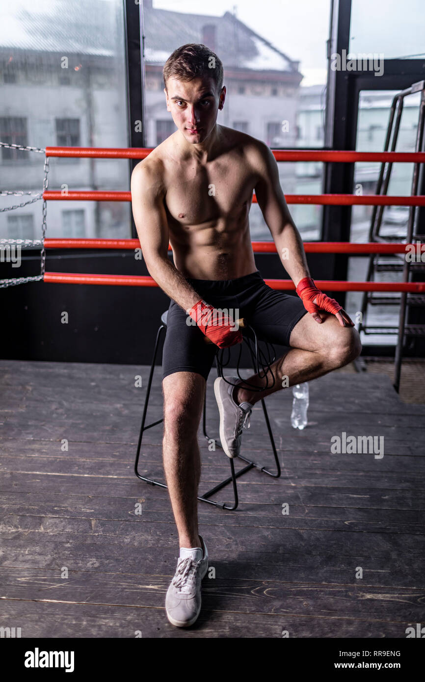 Boxer uomo con corda seduti su una sedia nell'anello Foto Stock