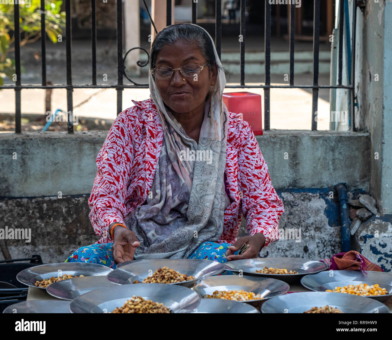 Donna vendita di sementi di uccello sul lato della strada, Yangon, Myanmar Foto Stock