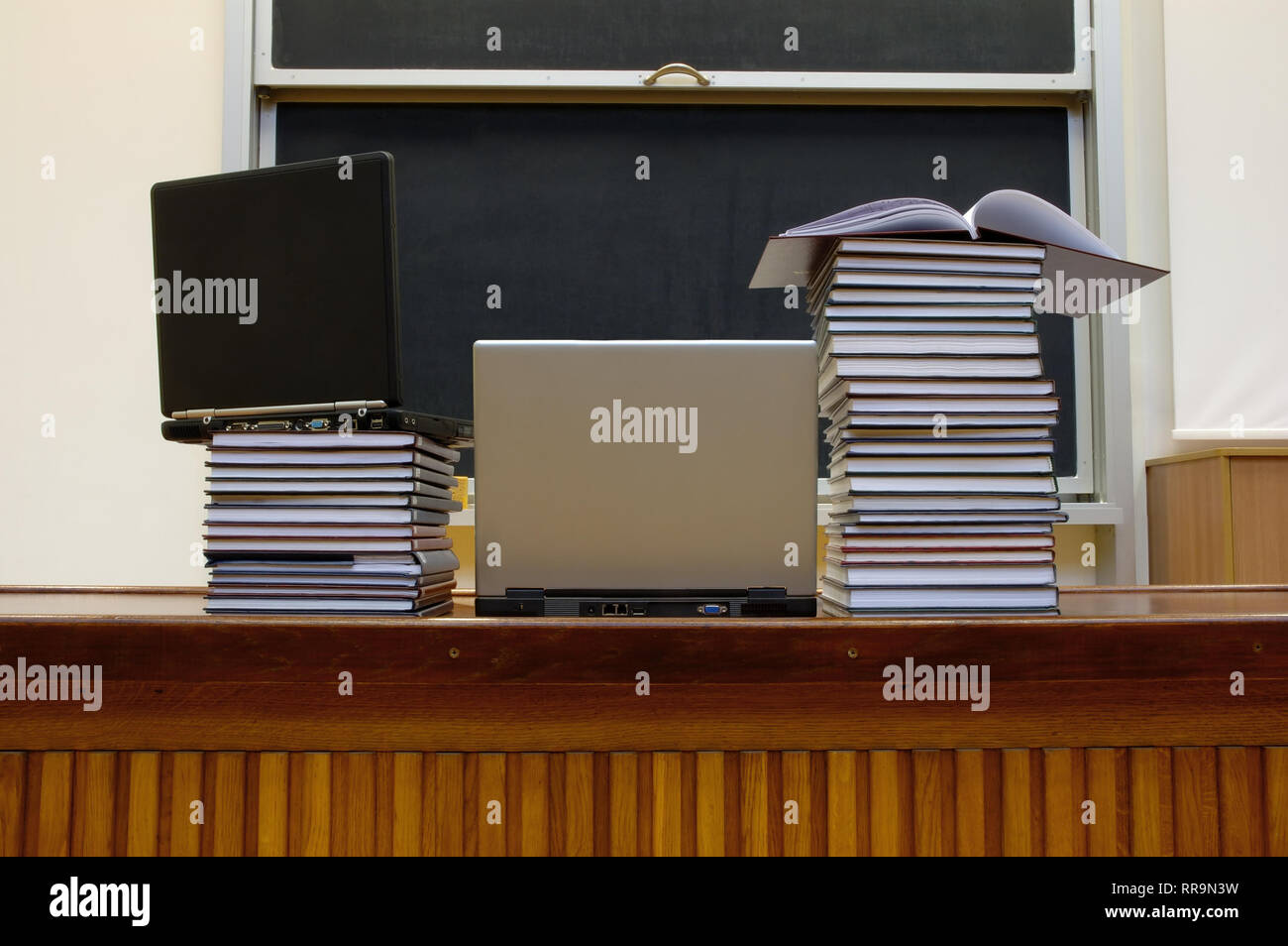 Laptop e libri giacente sul tavolo in aula magna Foto Stock