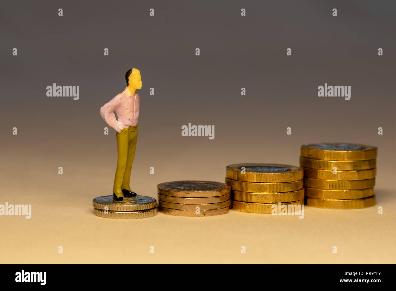 L'uomo salendo su un aumento delle pile di monete d'oro. Risparmio di denaro per il pensionamento, Affari Carriera o il concetto di investimento. Foto Stock