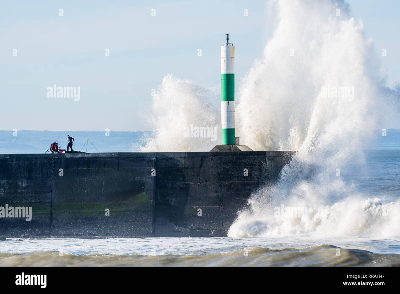 Aberystwyth Wales UK, lunedì 25 febbraio 2019. Regno Unito Meteo: un grande rigonfiamento atlantico, combinato con l'alta marea, portare enormi ondate di laminazione per il faro del porto di Cardigan Bay seashore in Aberystwyth, su di un soleggiato brillante ed eccezionalmente caldo Febbraio mattina. Photo credit: keith morris/Alamy Live News Foto Stock