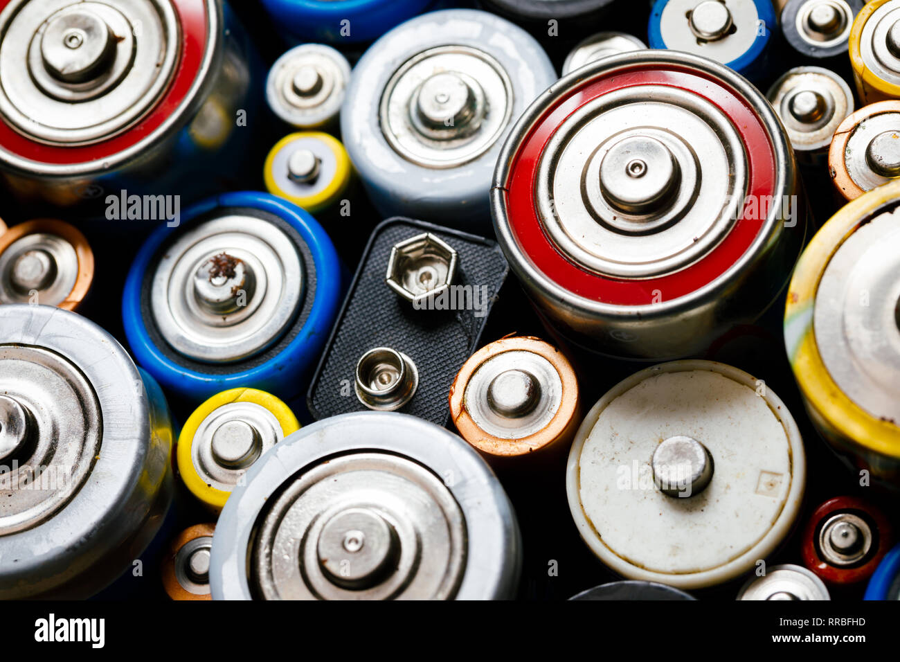 Oggetto di dumping le batterie alcaline usate di vari tipi (C AA AAA D 9V) pronto per il riciclaggio - rifiuti tossici e questioni ambientali concetto Foto Stock
