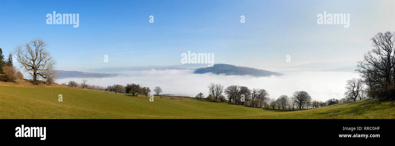 Una nuvola drammatica inversione di prendere posto nel Parco Nazionale di Brecon Beacons su un luminoso mattino senza nuvole in febbraio, Wales, Regno Unito Foto Stock