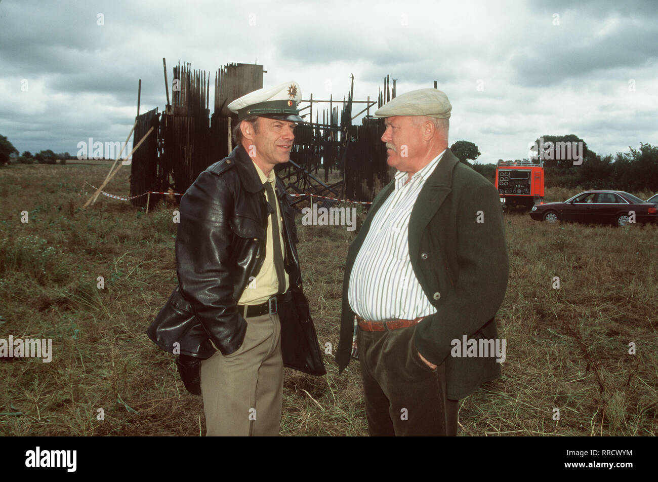 Die männer vom k3 / in einem Dorf in der Nähe Hamburgs werden auf das Eigentum des reichen Bauern Herford immer wieder Anschläge verübt ... / Foto: Schöller (HARTMUT RECK, l.) mit Herford (HANS TEUSCHER) vor dessen abgebrannter Scheune. / / 33951 , 15DFAN3MAE2 / Überschrift: DIE MÄNNER VOM K3 / BRD 1994 Foto Stock