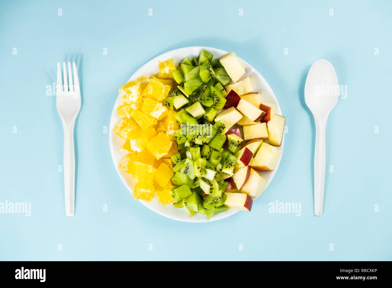 Impianto basato dieta alimentare concetto. Vista superiore della frutta fresca su di una piastra a fondo azzurro Foto Stock