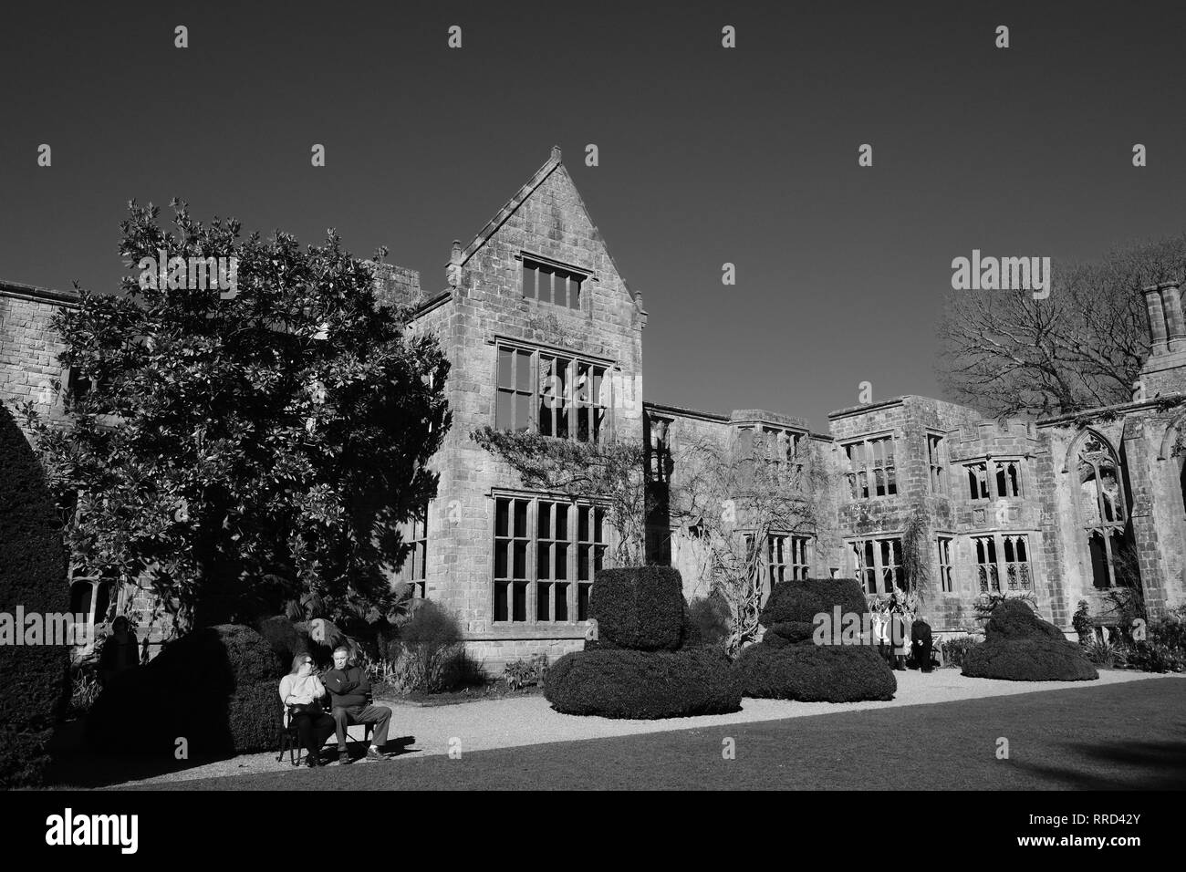 Giovane seduto di fronte a casa in rovina nel Giardino Inglese West Sussex England Foto Stock