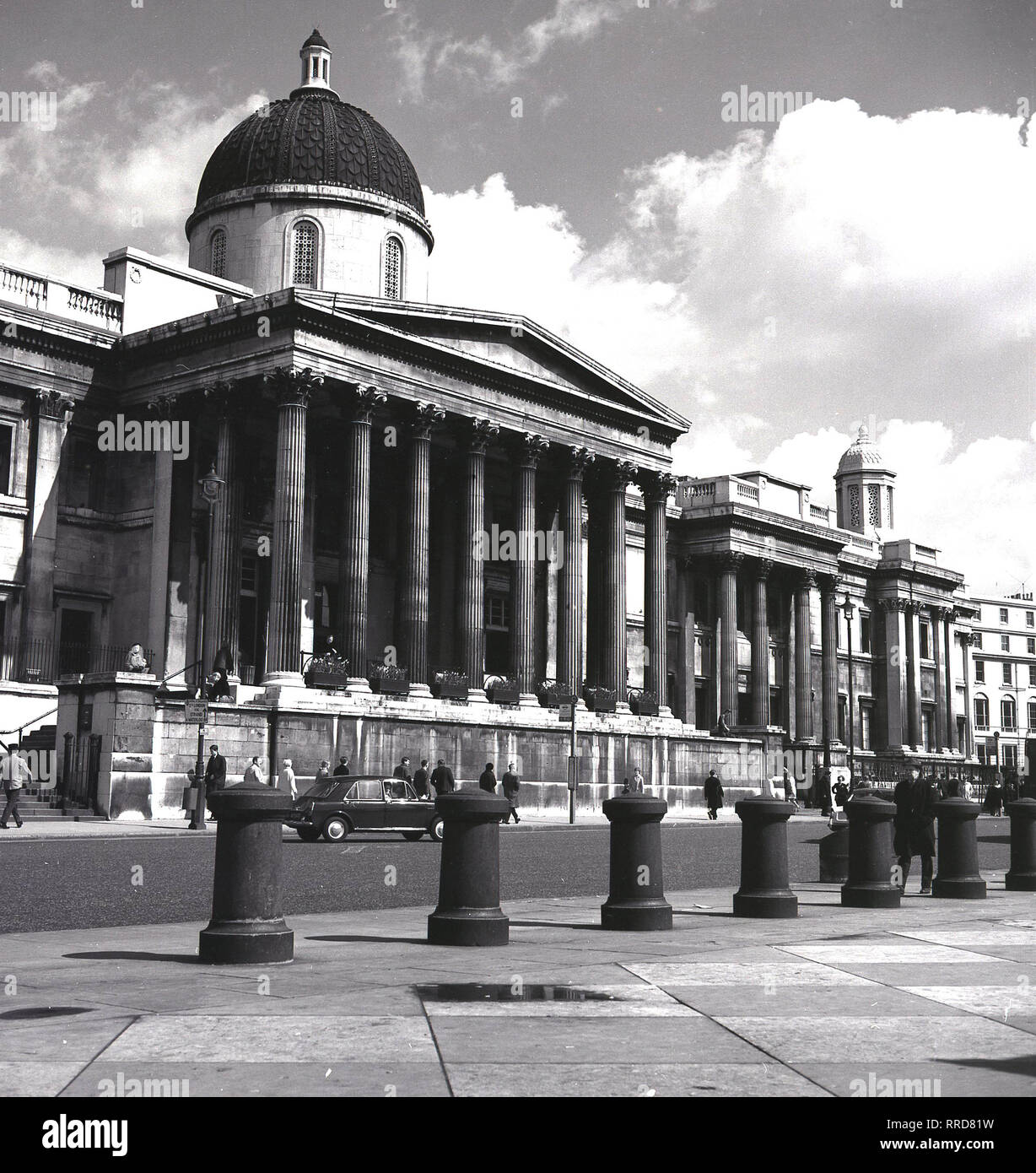 Anni sessanta, storico vista frontale di ingresso colonnato alla National Gallery, a Trafalgar Square a Londra, Inghilterra, Regno Unito. Fondata nel 1824, il museo di arte contiene una delle più grandi collezioni di dipinti al mondo. Foto Stock