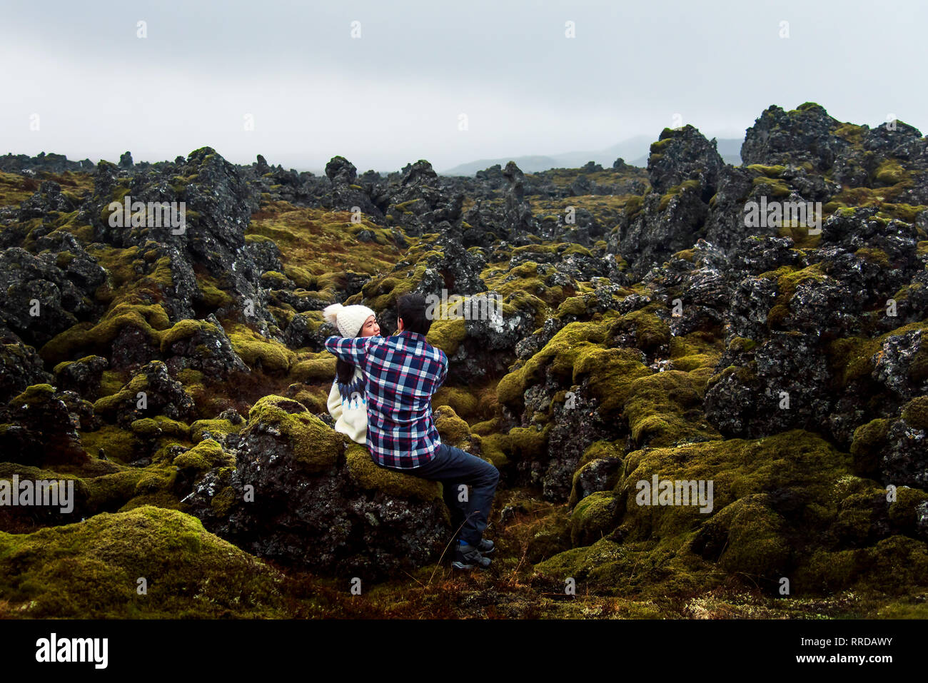 Giovane abbracciando in un pittoresco campo di lava in Islanda Foto Stock