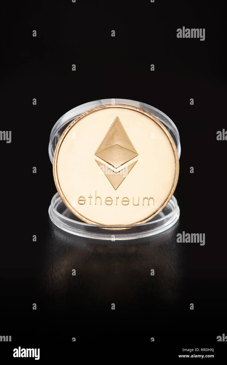 Ethereum medaglia d'oro in moneta trasparente contenitore su sfondo nero, tracciato di ritaglio Foto Stock