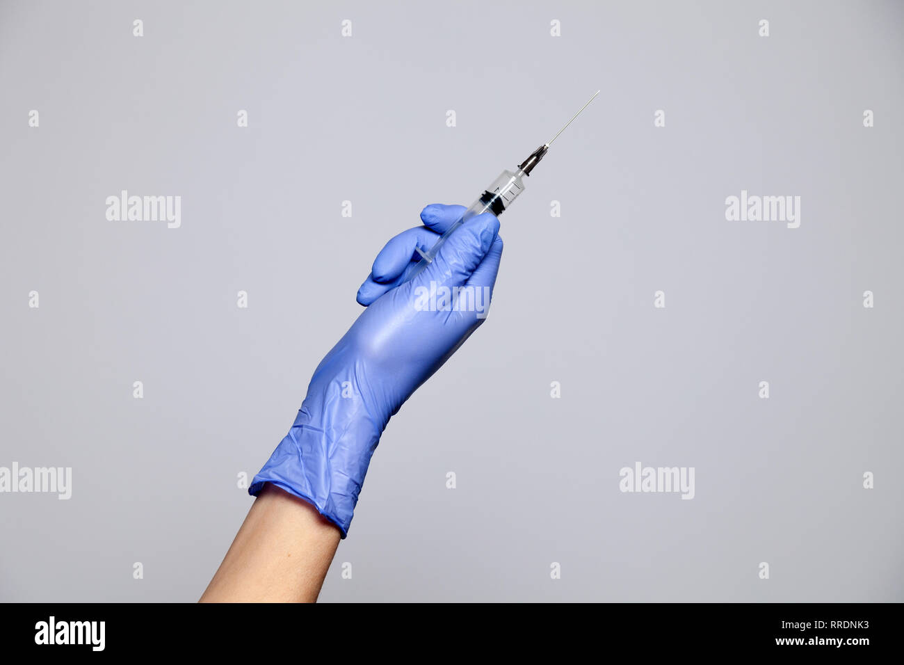 Primo piano medico la mano in gomma guanto Porpora tenendo la siringa trasparente senza tappo. Isolato su sfondo bianco. Nozione di rifiuto di vaccinatio Foto Stock