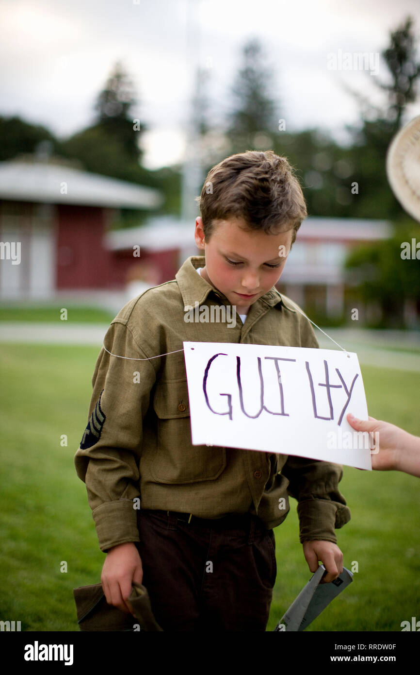Ragazzo in uniforme militare con colpevole segno Foto Stock