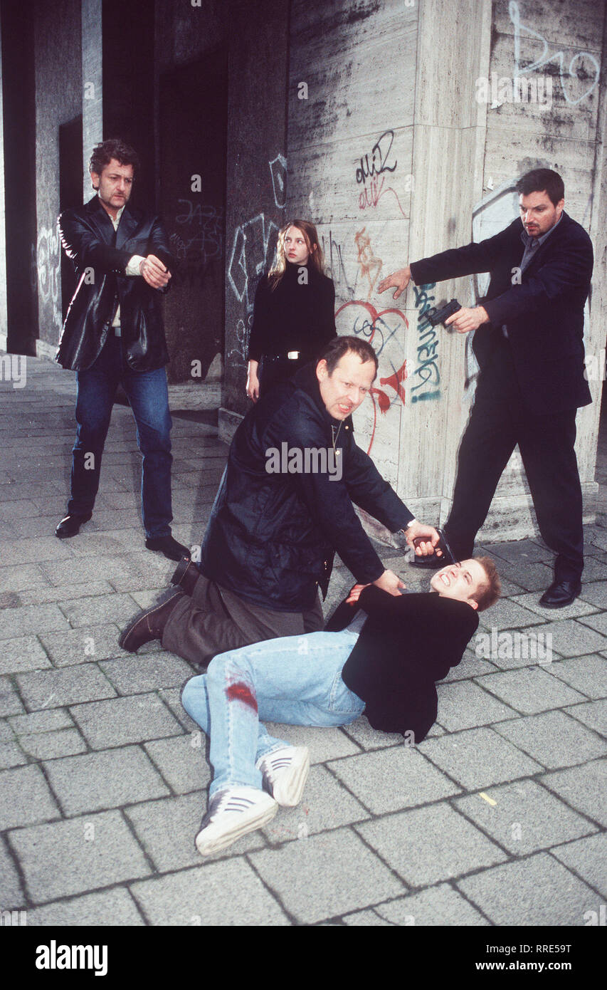 TATORT / Der Trippler / Die zehnjährige Susi Karsten wurde ermordet. Offensichtlich kannte das Mädchen seinen Mörder. / Szene: Susis Vater Thomas Karsten (Axel MILBERG) bedroht Jost Stollberg (NIELS BRUNO SCHMIDT), einen Freund von Susis siebzehnjähriger Schwester Melanie, mit einer pistole. Die Kommissare Ritter (DOMINIC RAACKE, l.) und Hellmann (STEFAN JÜRGENS, r.) kommen mit Melanie (KATHARINA SCHÜTTLER) zu Hilfe. / , DFATatort2 / Überschrift: TATORT / D 2000 Foto Stock
