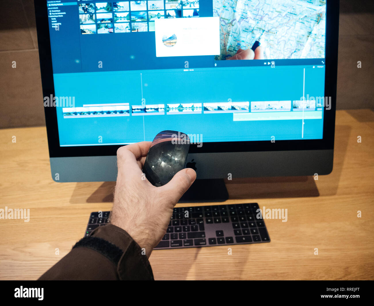Parigi, Francia - Jan 10, 2018: il cliente tenendo il Magic Mouse vicino al nuovo Apple iMac Pro computer workstation in Apple Store - lo spazio grigio workstation dotate di CPU Intel Xeon e RADEON GPU Vega Foto Stock