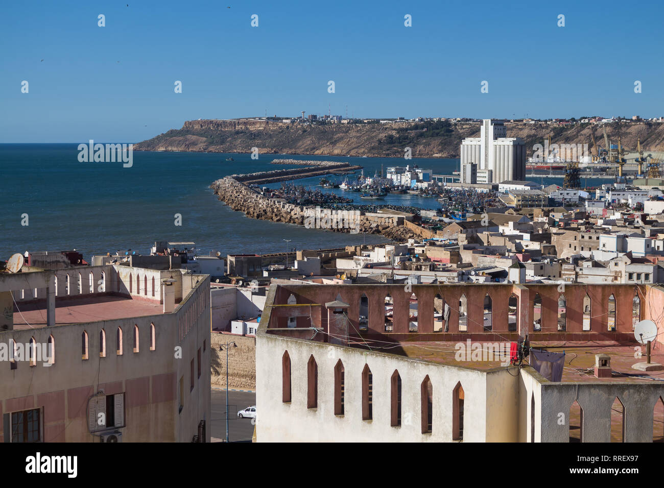 Vista del cielo sulla città vecchia e la parte industriale del porto. Scogliere in background. L'acqua dell'Oceano Atlantico e il blu del cielo. Safi, Marocco. Foto Stock