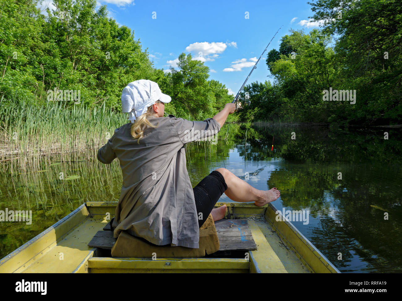 La bambina in una barca da pesca in un lago. Vista pittoresca della natura selvaggia nella foce del fiume Dnieper Foto Stock