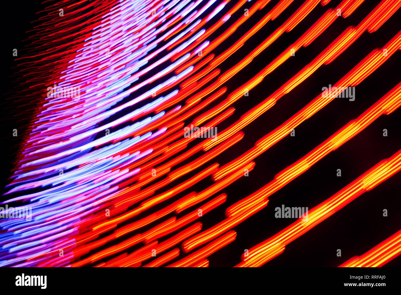 Rosso-arancio e blu-viola incandescente linee in movimento su sfondo scuro. Primo piano la foto in orizzontale. Foto Stock