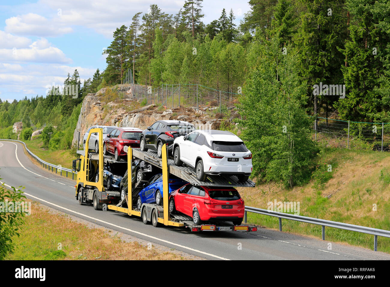Salo, Finlandia - 8 Giugno 2018: Giallo veicolo carrello con carico di nuove vetture guida su autostrada rampa sulla giornata di sole dell'estate, in vista posteriore Foto Stock