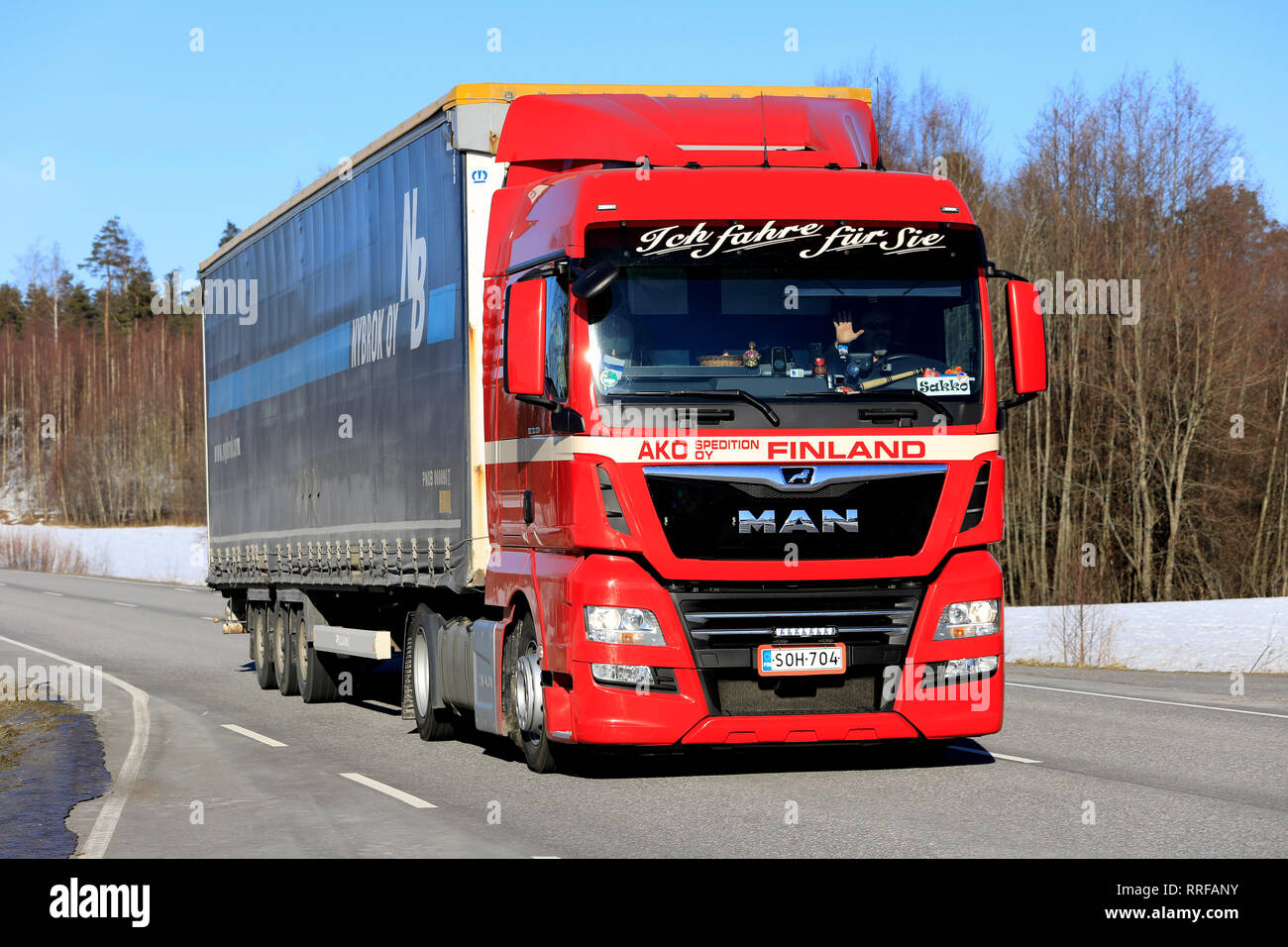 Salo, Finlandia - 22 Febbraio 2019: uomo rosso TGX 18.450 camion di AKO Spedition Oy tira rimorchio carico lungo l'autostrada nel sud della Finlandia il giorno di inverno Foto Stock