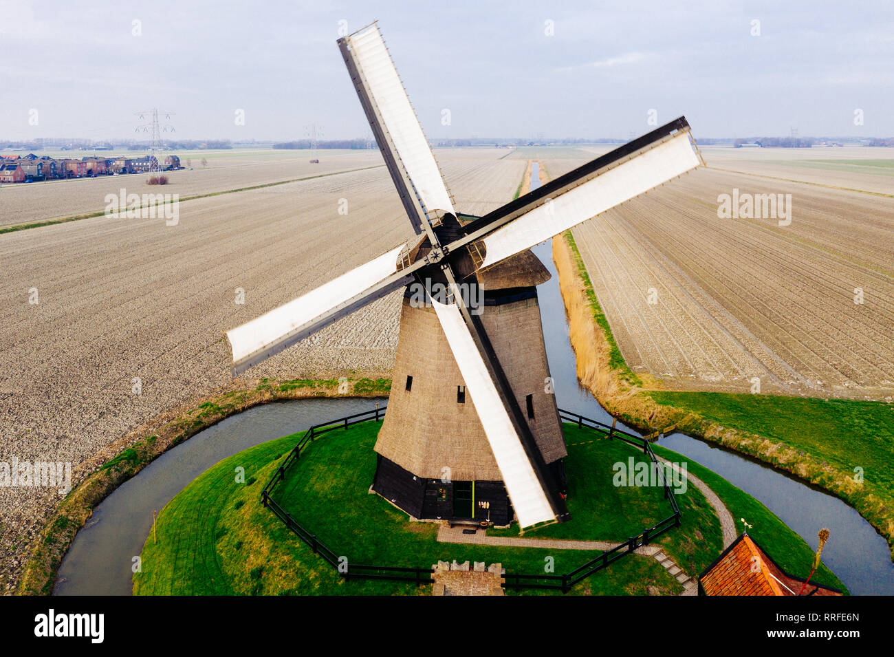 Tipico mulino a vento olandese del XVII secolo il colpo da sopra con un drone circondata da un canale nei campi dell'Olanda Foto Stock