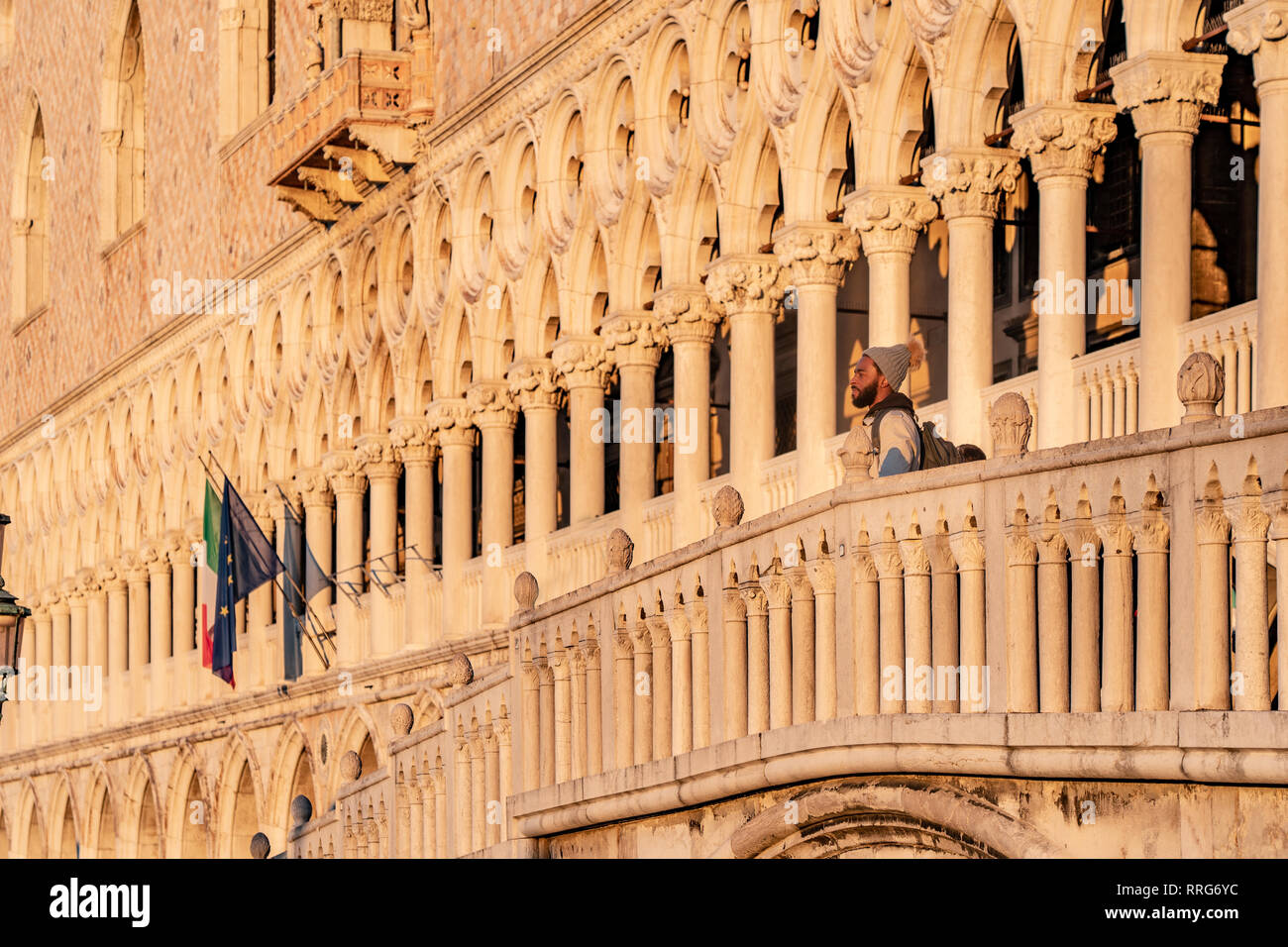 Un uomo si affaccia dal ponte di fronte al Palazzo del Doge di Venezia a sunrise. Da una serie di foto di viaggio in Italia. Foto Data: martedì, Febr Foto Stock