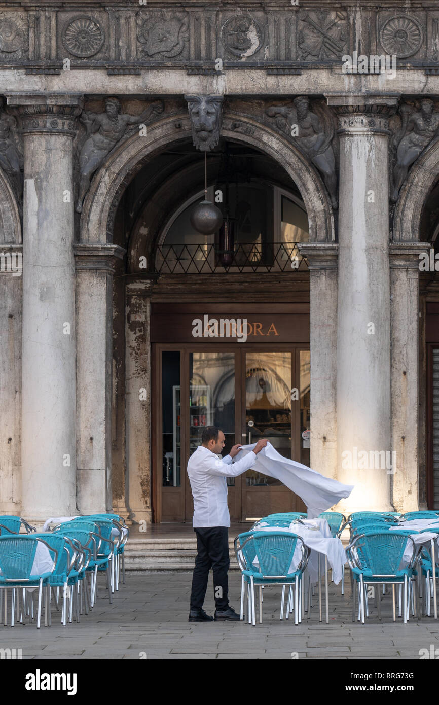 Un cameriere prepara le tabelle in un caffè di Piazza San Marco a Venezia. Da una serie di foto di viaggio in Italia. Foto Data: martedì 12 febbraio, 2019. Pho Foto Stock
