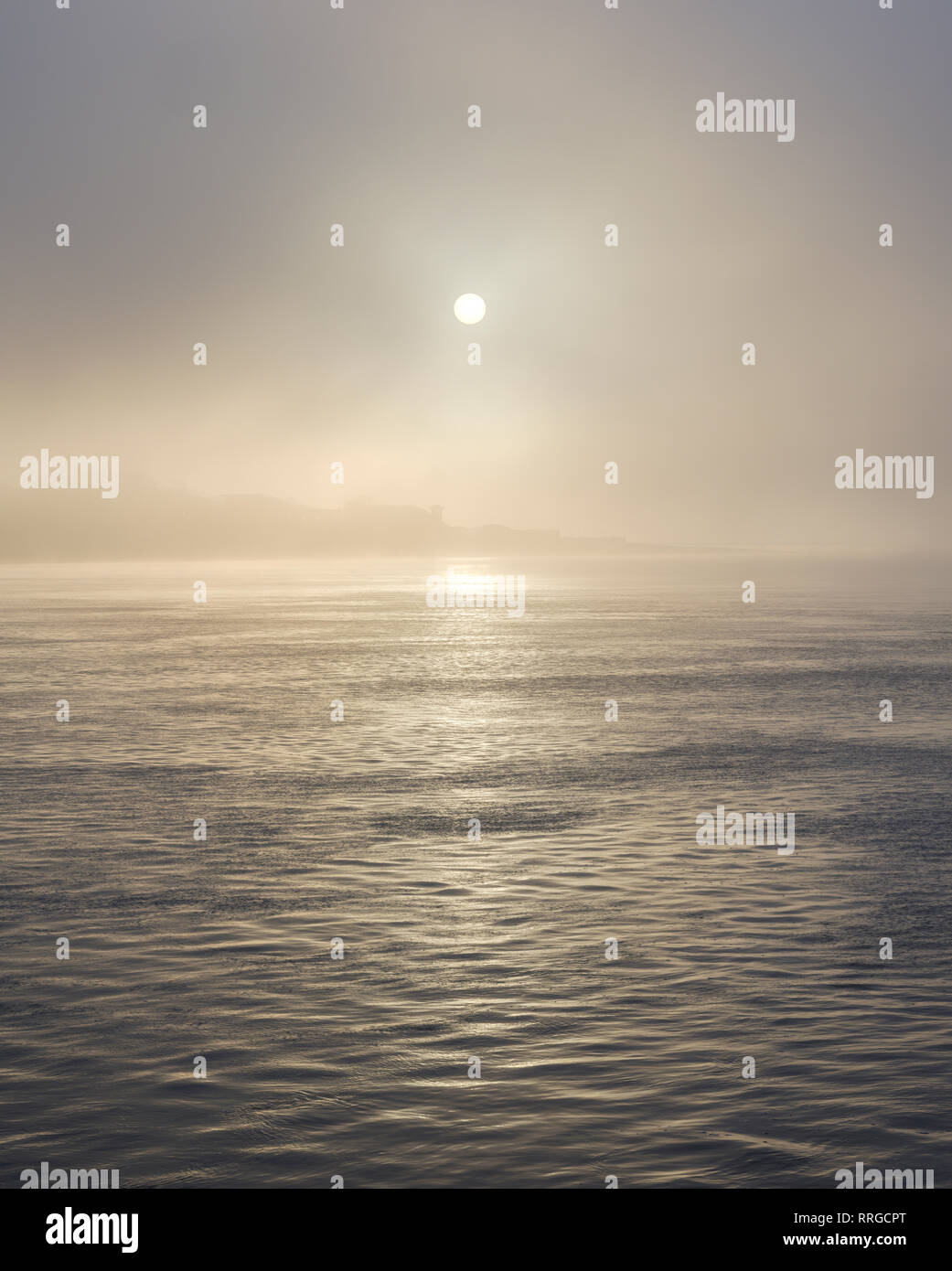 Il sole splende attraverso la fitta nebbia di fronte al mare a Exmouth, Devon, Inghilterra, Regno Unito, Europa Foto Stock