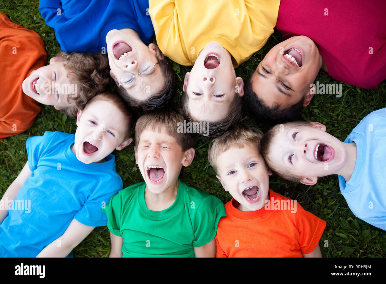 Un gruppo di ragazzi che urlavano in erba al di fuori Foto Stock