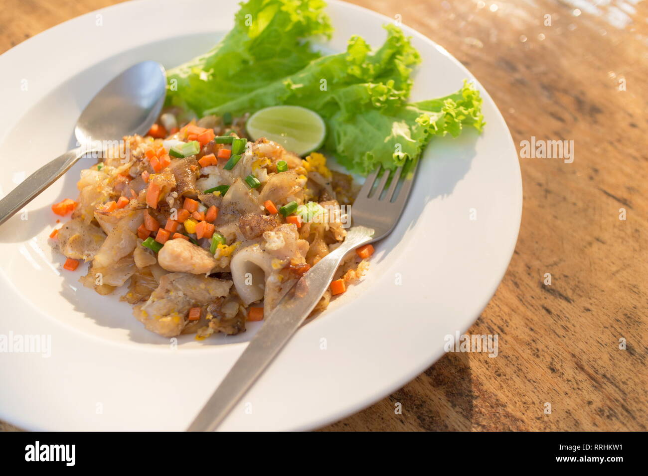 Thai noodles fritti "Pad Thai' con le verdure su una tavola di legno. Foto Stock