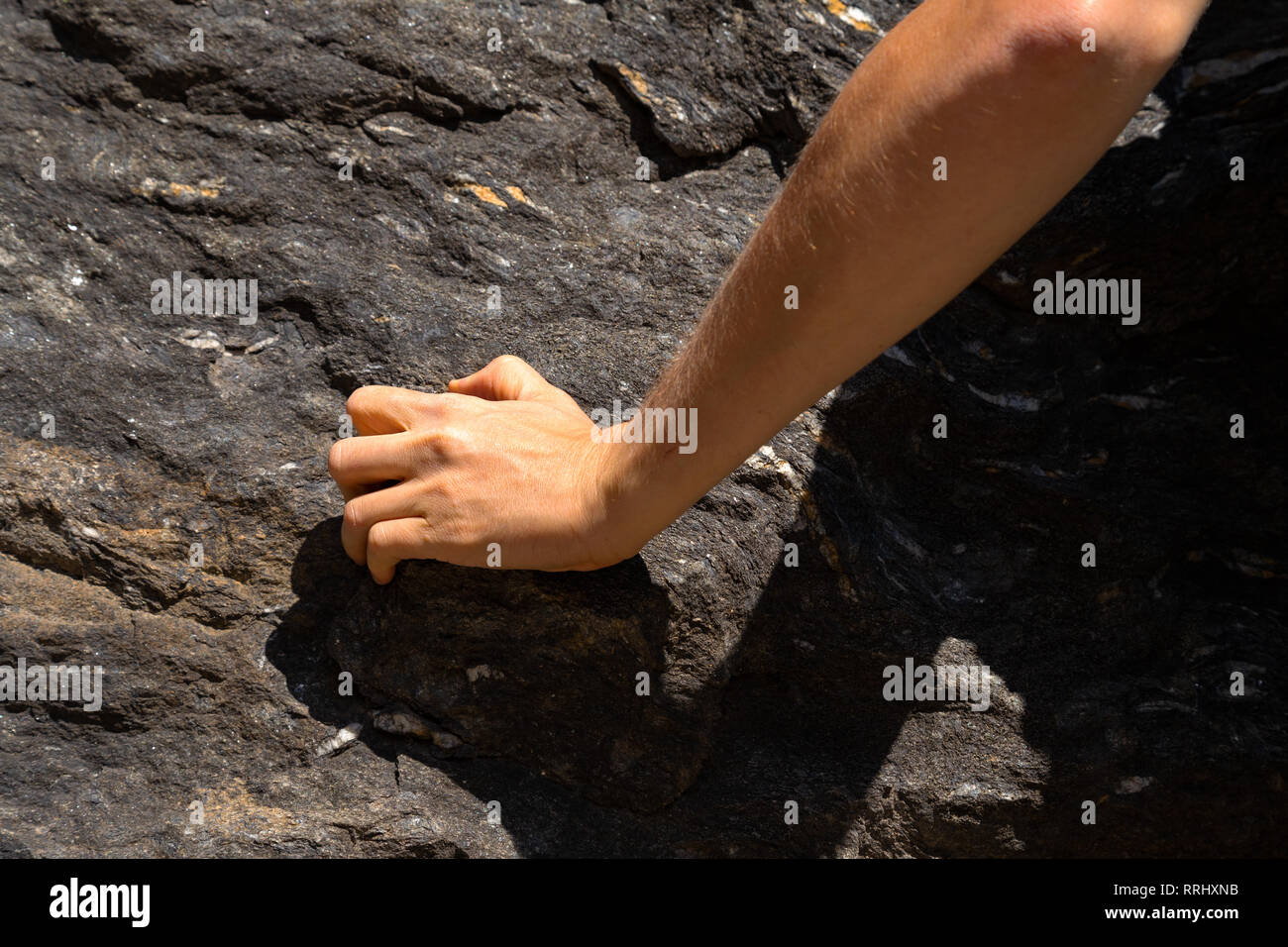 Canto di un giovane uomo caucasico arrampicata su una roccia in Svizzera Foto Stock
